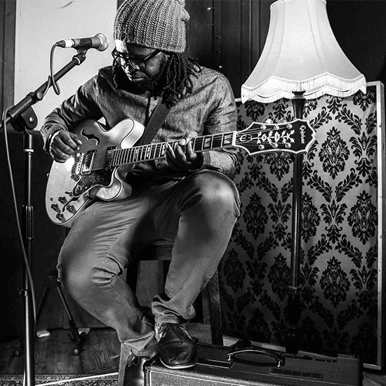 Mide With Guitar In Black And White In Front Of Lamp