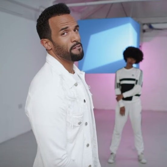 craig-david-white-aint-giving-up-music-video-denim-jacket-blue-square-background-dancer-curly-fro