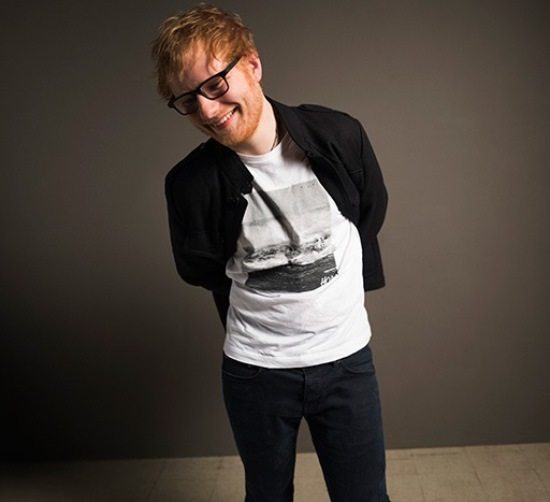 ed-sheeran-black-glasses-black-blazer-tshirt-brown-wall